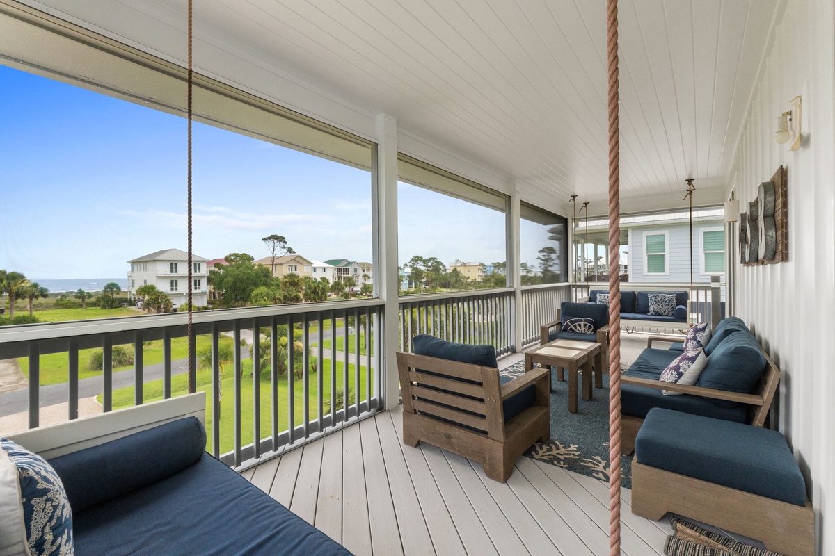 Your screened porch offers relaxing seating with neighborhood and green views, plus charming rope swing accents for a coastal vibe.