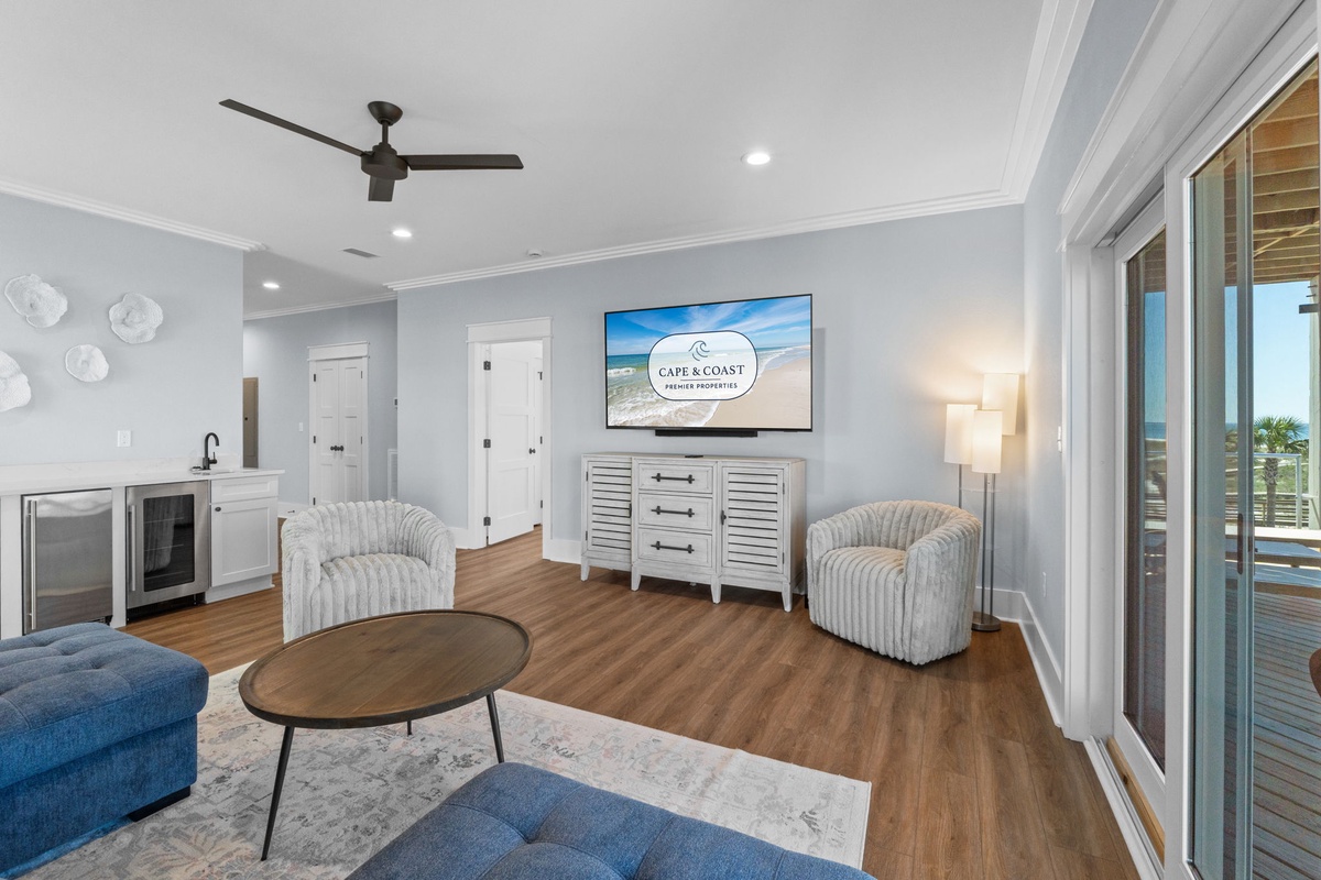 Unwind in your bright, airy living room with coastal touches and a glimpse of ocean beyond. Plush seating, a flat-screen TV, and a wet bar make it easy to relax after beach days.