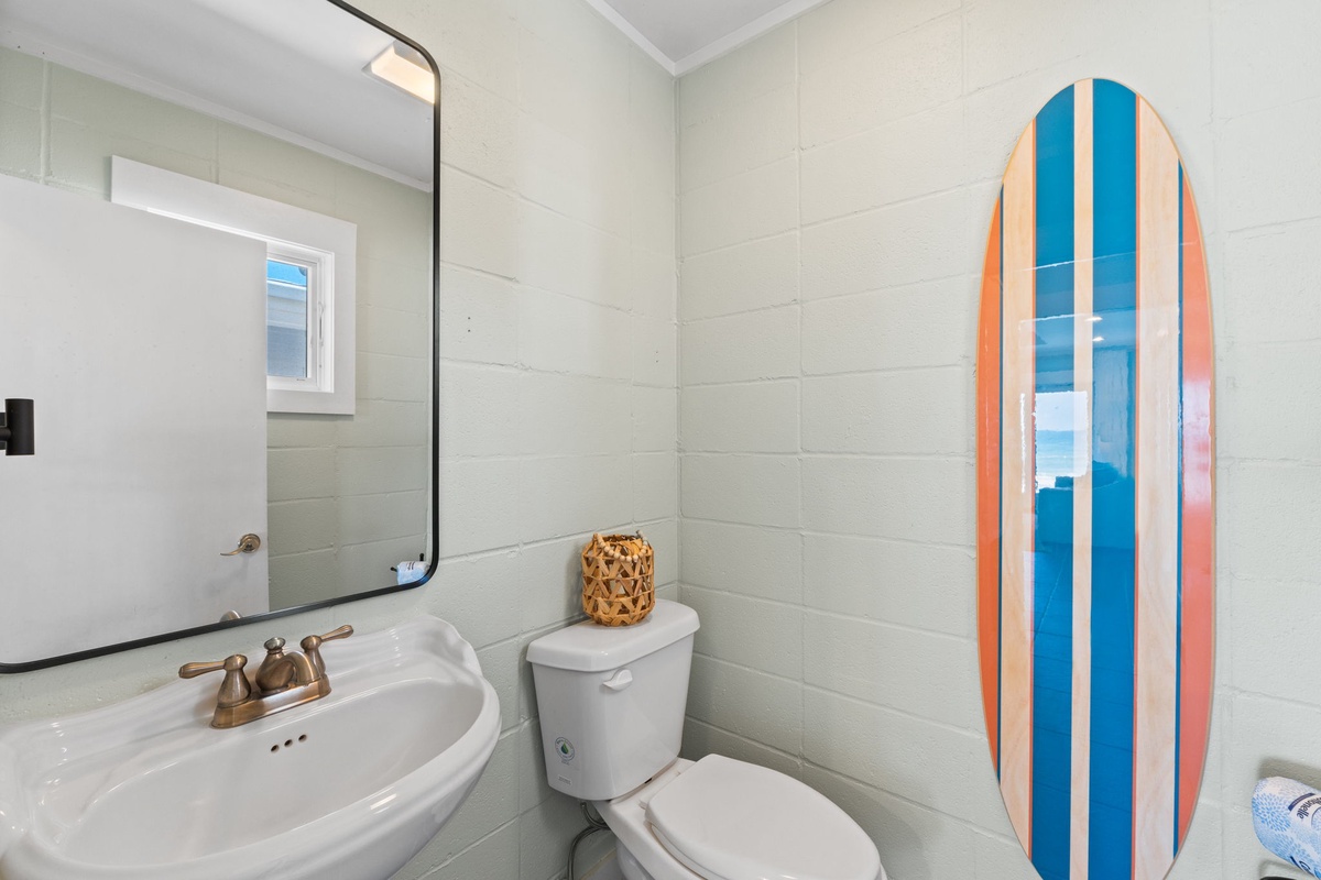 Freshen up in this bright beach cottage bathroom, where coastal vibes meet everyday comfort. The vintage-inspired sink and playful surfboard art set a fun, relaxed tone for your seaside getaway.
