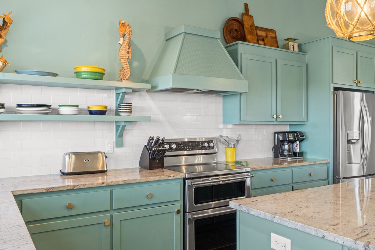 Cook memorable meals in your fully equipped coastal-inspired kitchen with modern appliances and charming turquoise cabinets.