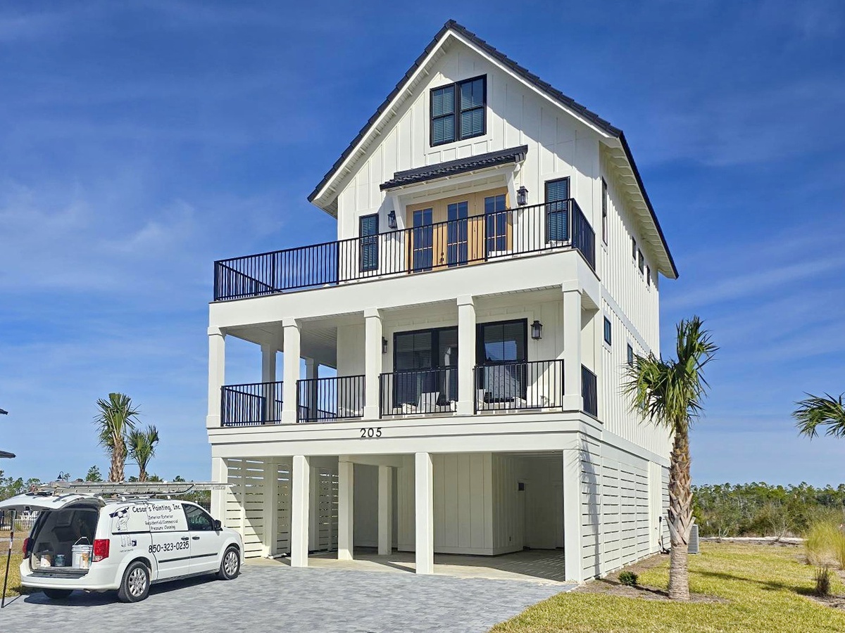 Modern coastal home with multiple balconies and tropical landscaping creates the perfect beachside retreat.