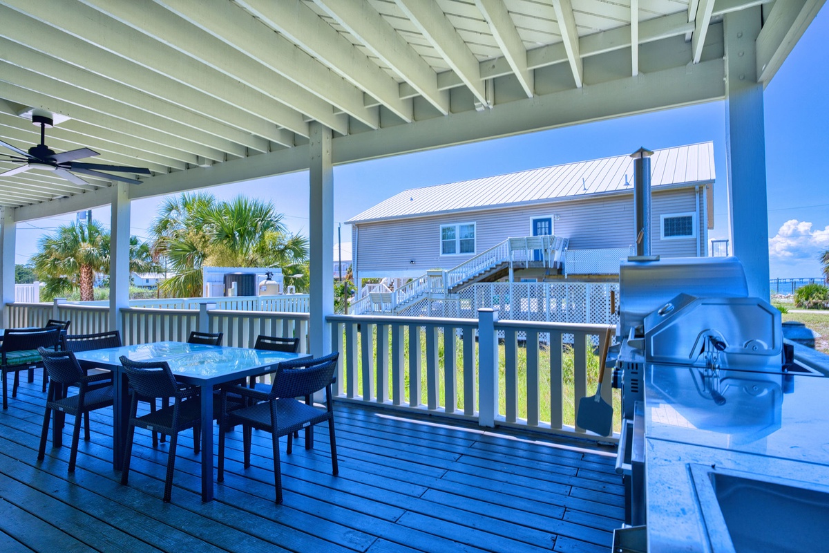Picture yourself grilling under this breezy covered deck while palm trees sway nearby—your perfect spot for outdoor dining and seaside meals with family and friends.