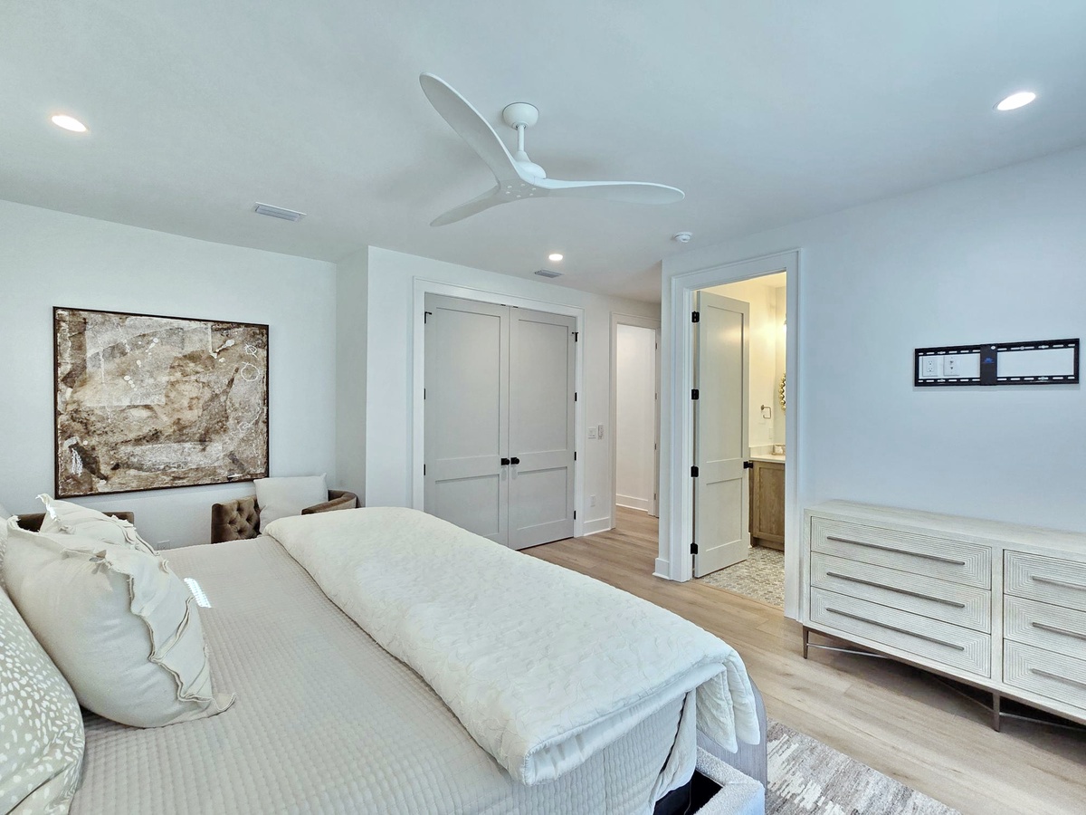 Drift off in this serene master bedroom where crisp linens and gentle ceiling fan breezes create your perfect sleep sanctuary.