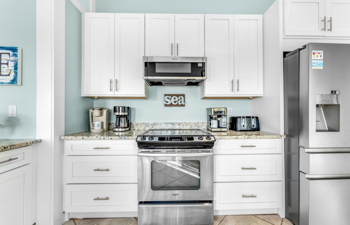 Your fully-equipped kitchen invites culinary adventures with granite counters, stainless appliances, and coastal charm—perfect for morning coffee or home-cooked meals.