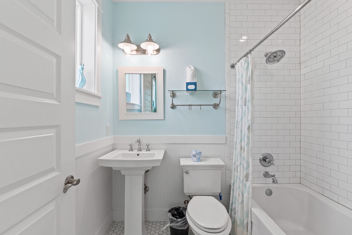 Refresh in your bright, coastal-inspired bathroom with classic subway tiles, pedestal sink, and relaxing soaking tub.