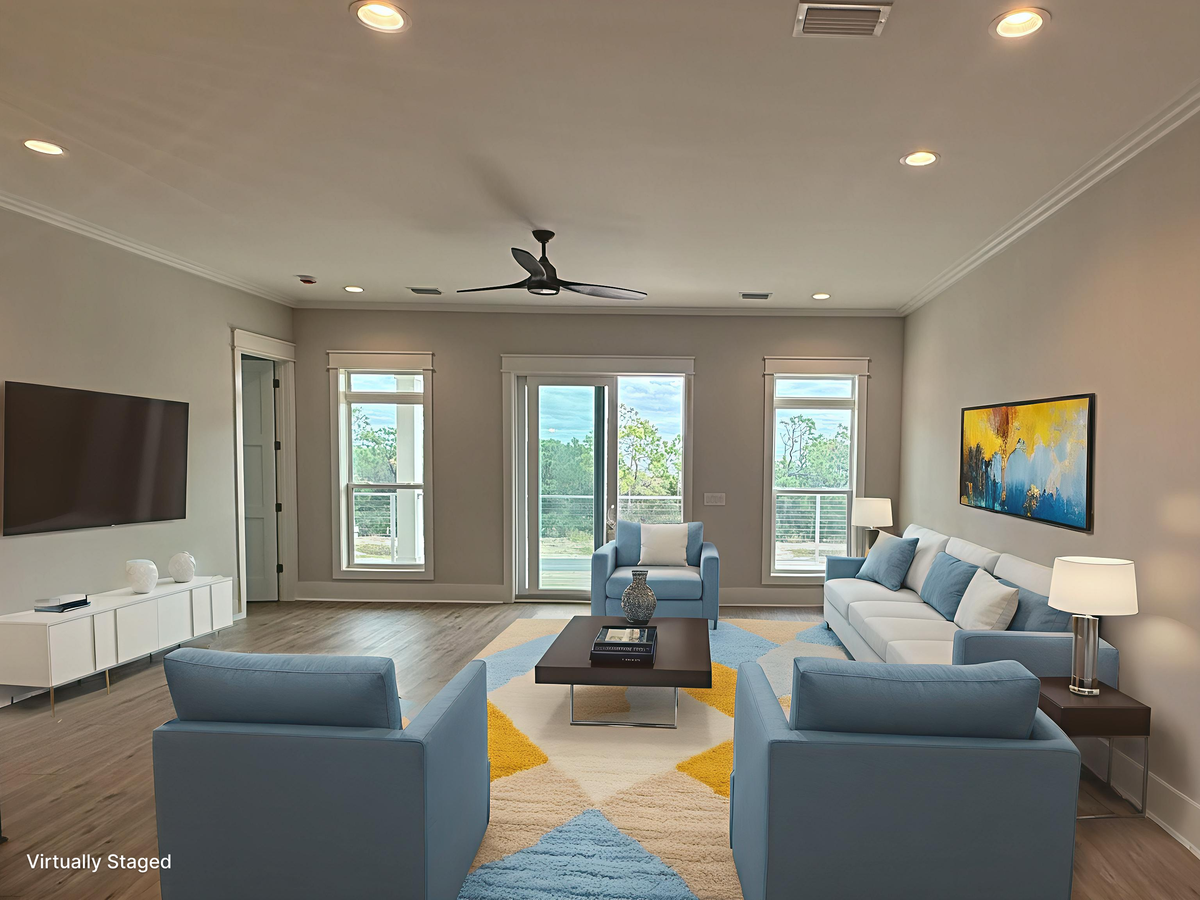 Sink into plush blue seating in your bright, modern living room where colorful art and natural light create the perfect space to unwind.