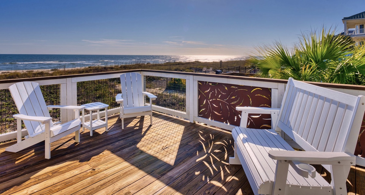 Unwind on your private deck with stunning ocean views, where white Adirondack chairs await your morning coffee ritual.