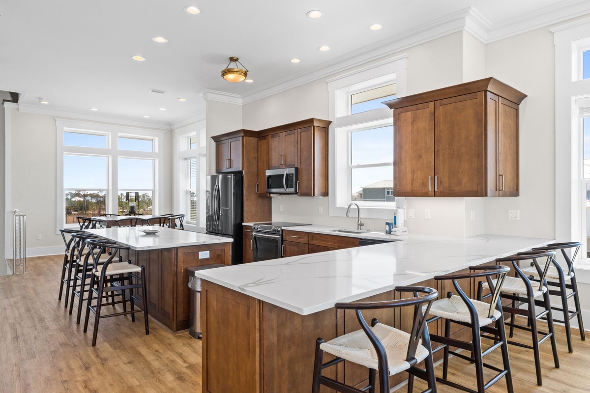 Your gourmet kitchen features warm wood cabinetry, pristine quartz countertops, and a spacious island perfect for gathering with loved ones.
