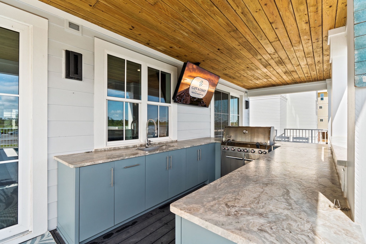 Gather around this covered outdoor kitchen where granite counters meet a top-of-the-line grill. Picture yourself hosting sunset cookouts with family under warm wood ceilings.