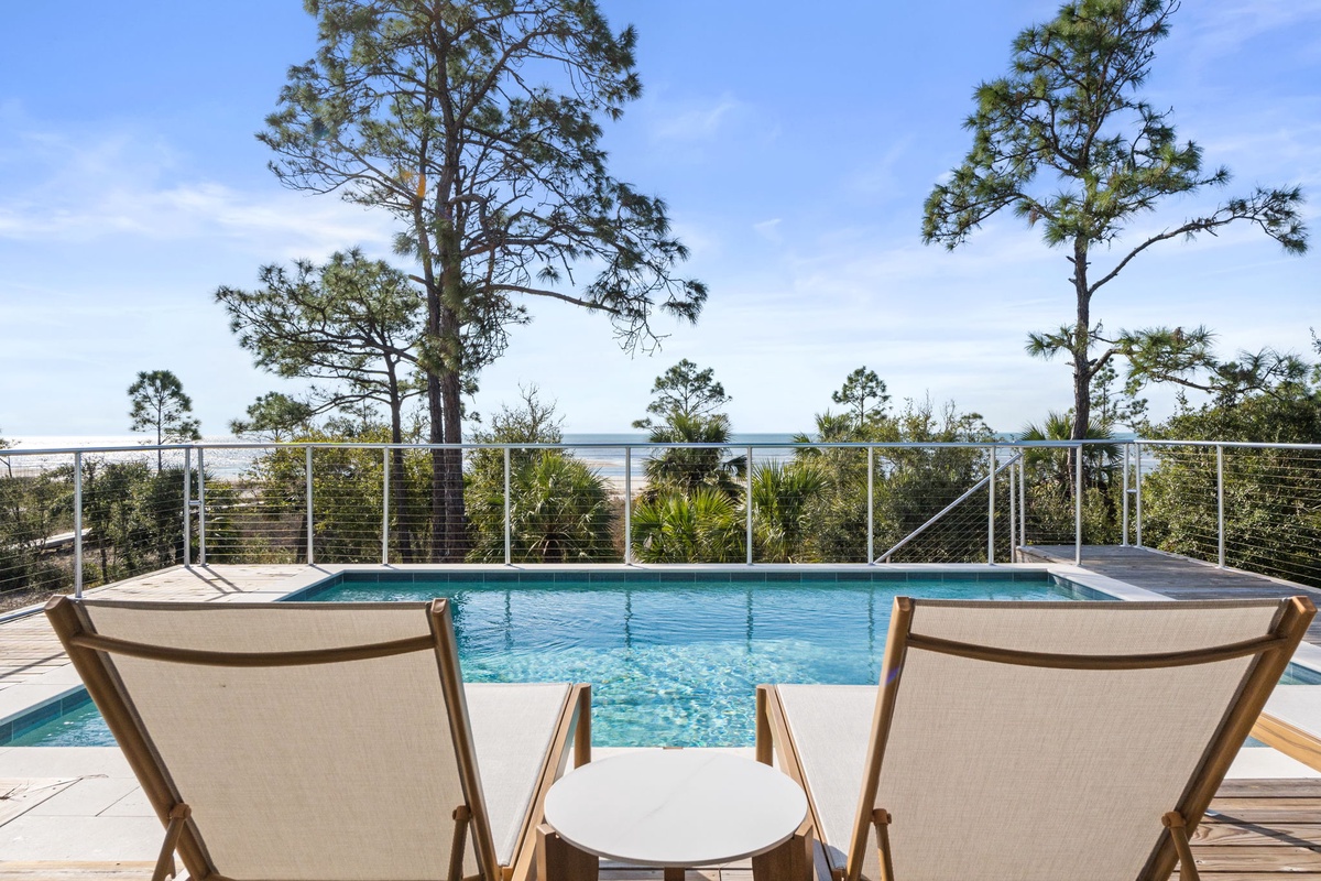 Relax poolside in comfortable lounge chairs while enjoying scenic views through the trees—your perfect retreat.