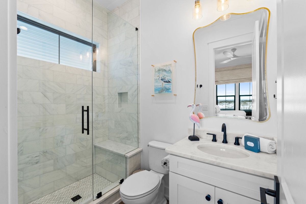 Unwind in your elegant bathroom featuring a spacious marble shower, modern vanity, and coastal-inspired touches that create a spa-like retreat.