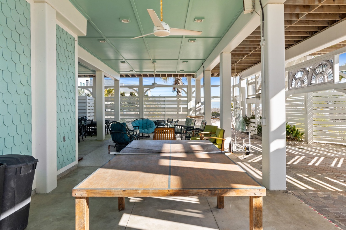 Unwind in your covered outdoor lounge with ping pong and comfortable seating, where coastal breezes and natural light create the perfect space to relax.
