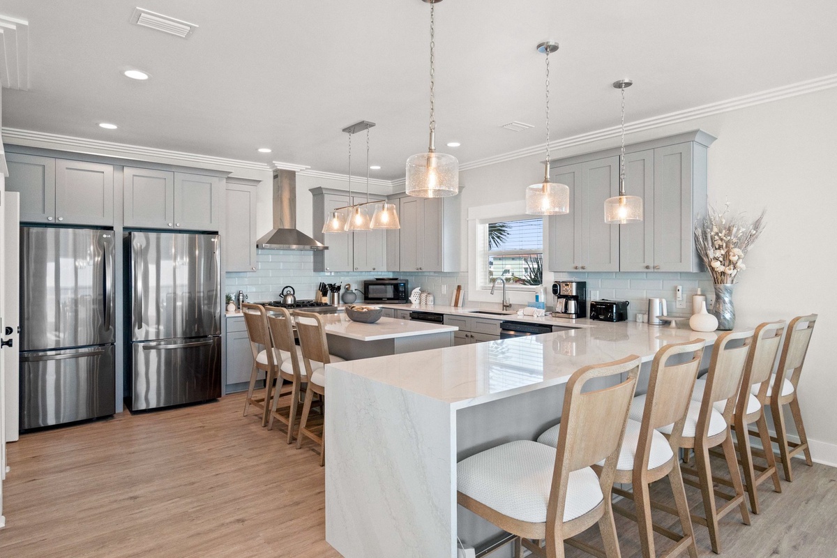 Gather around this stunning chef's kitchen featuring pristine quartz countertops, premium stainless appliances, and elegant pendant lighting for memorable culinary experiences.