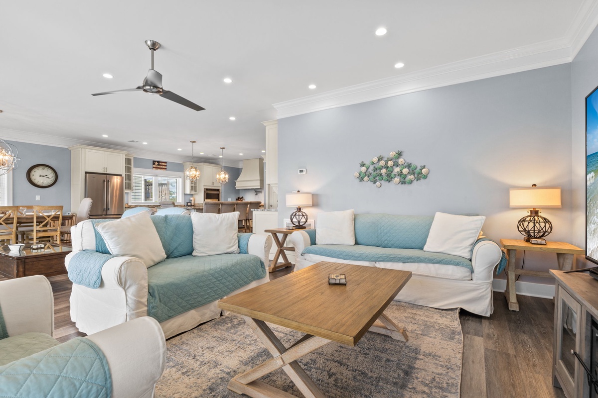Unwind in your bright, open living room where coastal blues meet modern comfort. Sink into plush sofas and enjoy the seamless flow to your fully equipped kitchen.