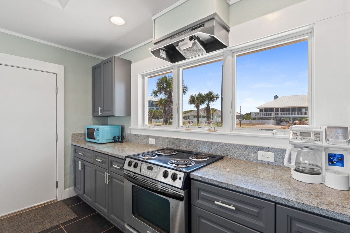 Your coastal kitchen is designed for easy meal prep with a stove, microwave, and coffee maker. Enjoy views of swaying palm trees and beachside charm through the large windows.