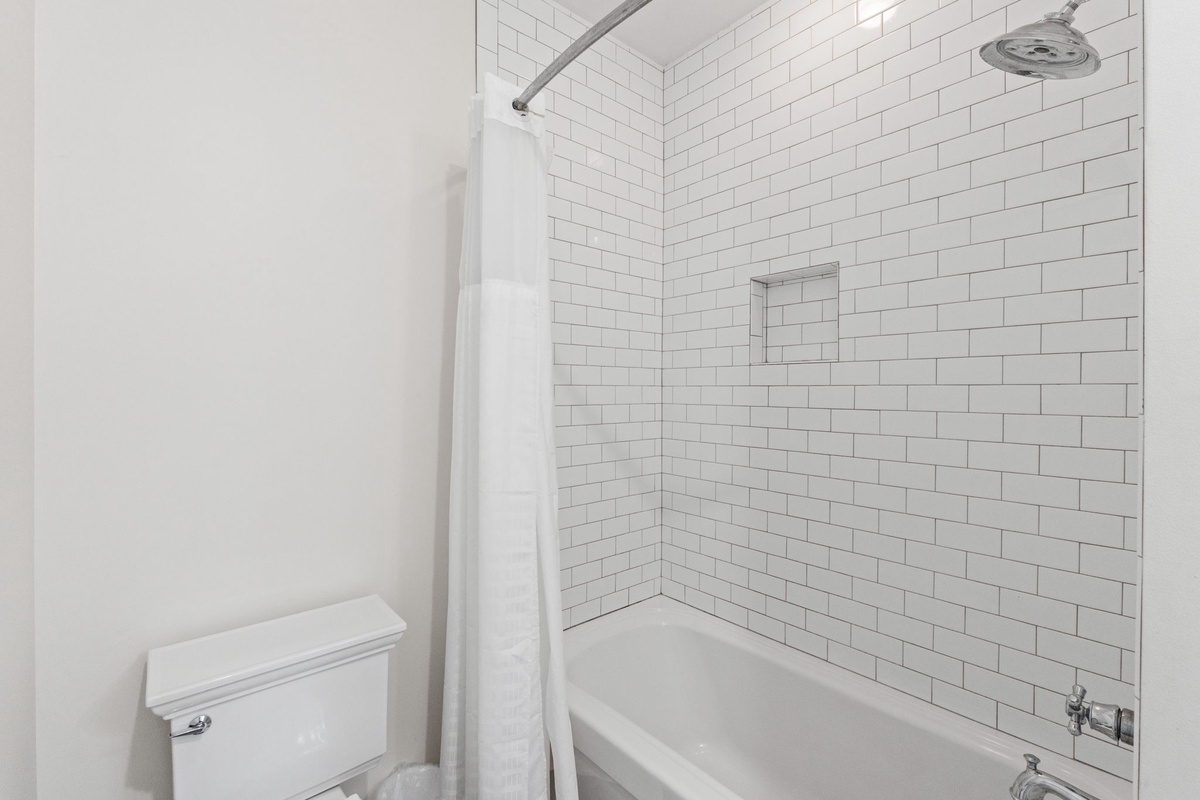 Step into your pristine bathroom featuring elegant subway tile and a refreshing tub-shower combo for your daily rituals.