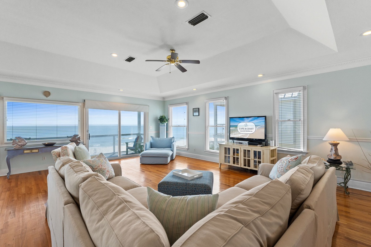 Unwind in this elegant living room where plush seating faces stunning ocean views through floor-to-ceiling windows.