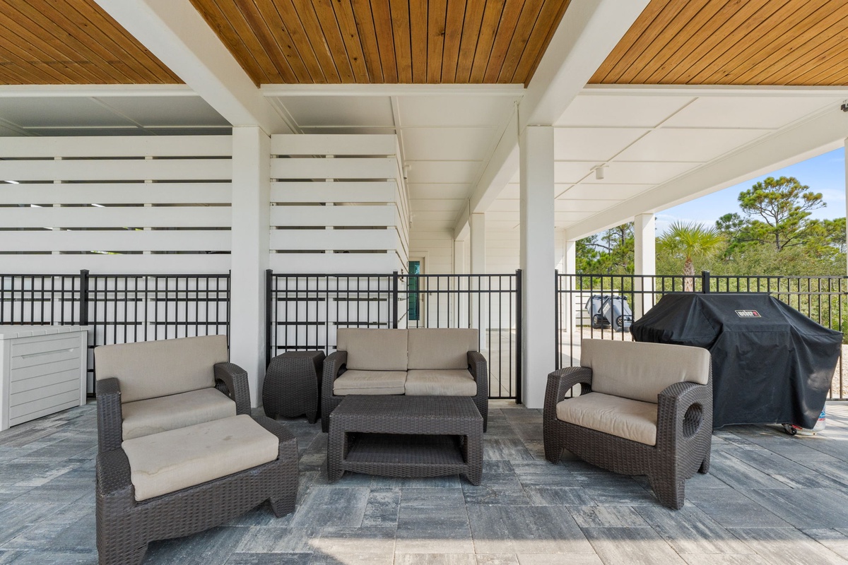 Settle into your private covered terrace with plush seating and a grill ready for outdoor dining. The warm wood ceiling and treetop glimpses create a perfect retreat for relaxing mornings or evening gatherings.