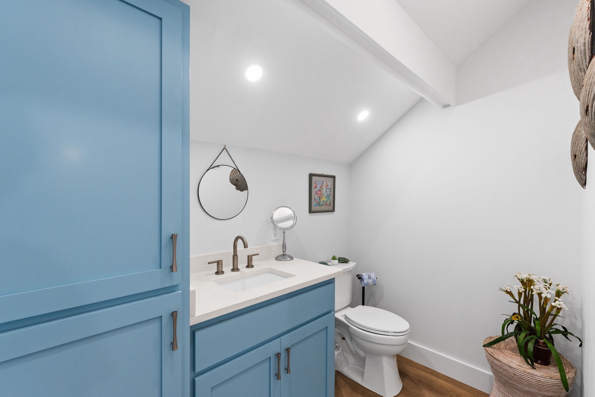 Freshen up in your cheerful bathroom with coastal-inspired touches, crisp white countertops, and thoughtful details like fresh flowers to make you feel right at home.