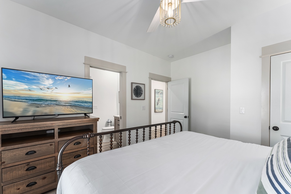 Your peaceful bedroom features a comfortable bed, large TV, and coastal art to help you unwind after days of adventure.