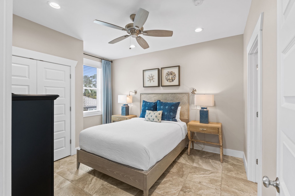 Unwind in your serene bedroom with coastal-inspired touches, soft linens, and natural light streaming in. The ceiling fan keeps you cool while matching nightstands add thoughtful symmetry.