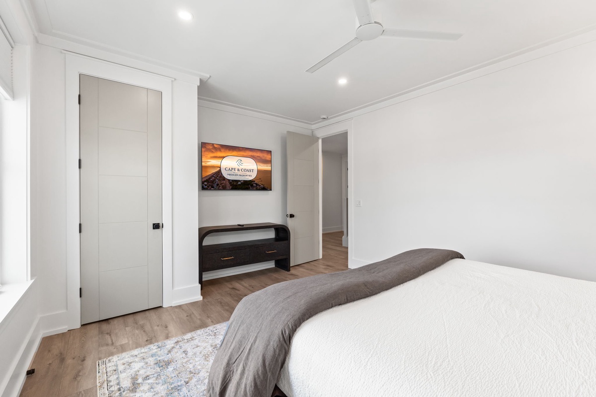 Unwind in your serene bedroom with crisp white linens, modern amenities, and thoughtful touches like a mounted TV for your evening entertainment.