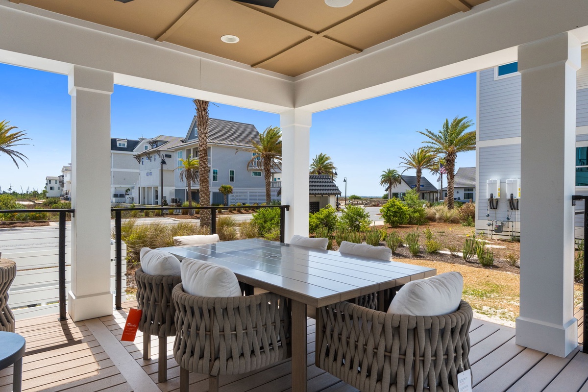 Your covered dining terrace offers the perfect spot for morning coffee or evening meals, with sweeping views of palm trees and coastal homes.