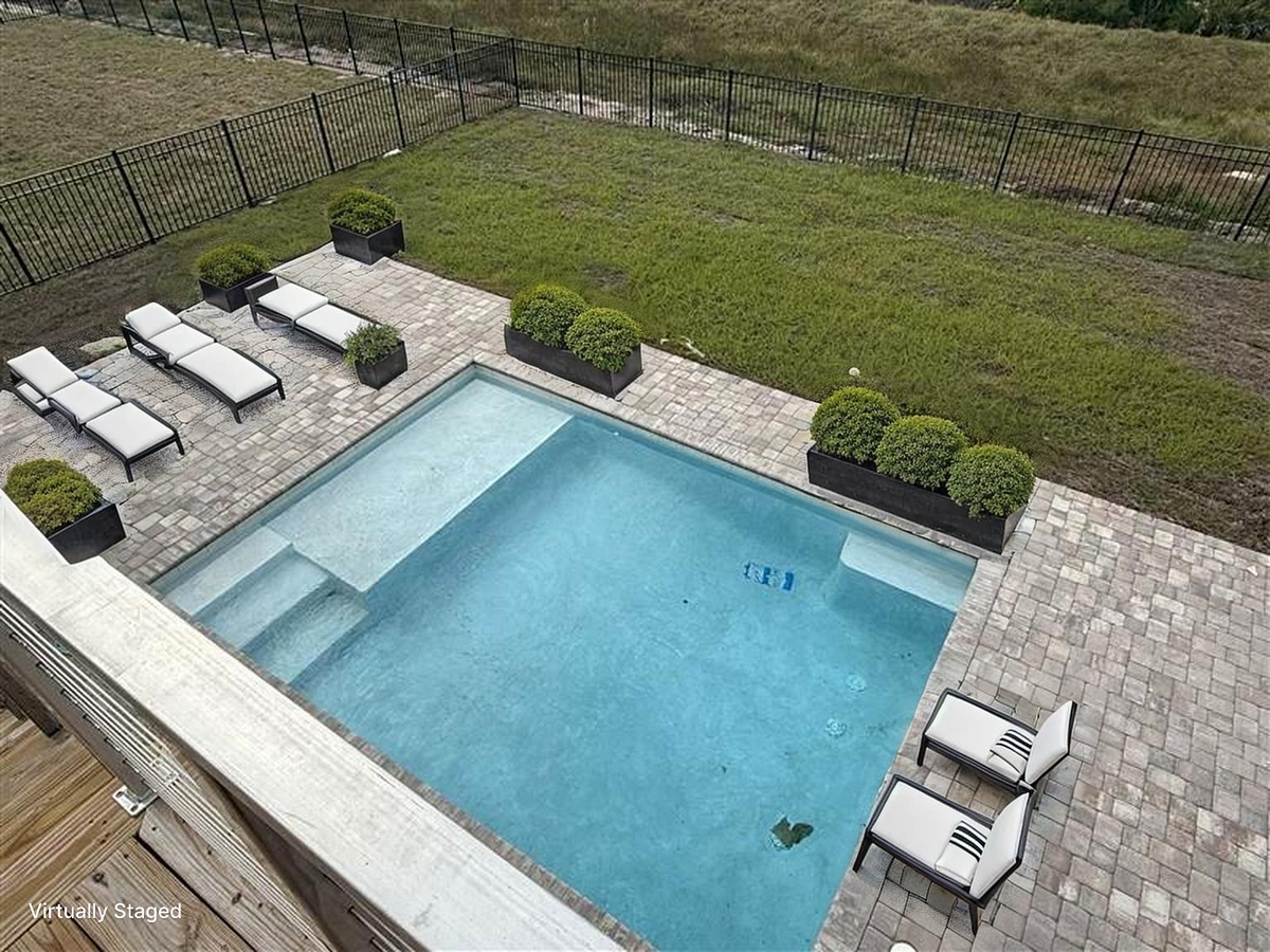 Aerial view of the beautiful pool area with lounge chairs and landscaped surroundings perfect for relaxation.