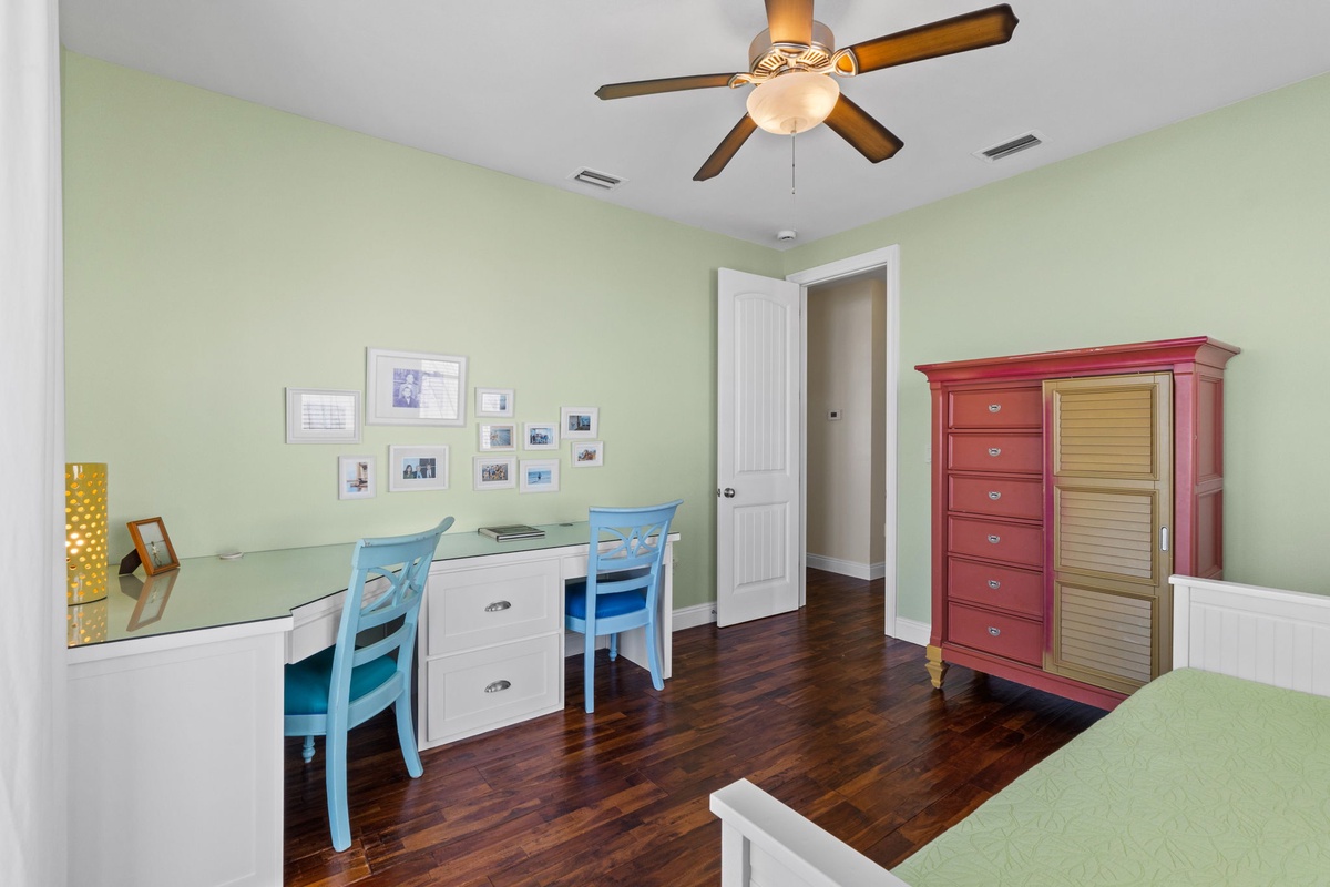 Settle into your bright workspace with coastal-inspired furnishings and plenty of room to spread out, all kept comfortable by the ceiling fan overhead.