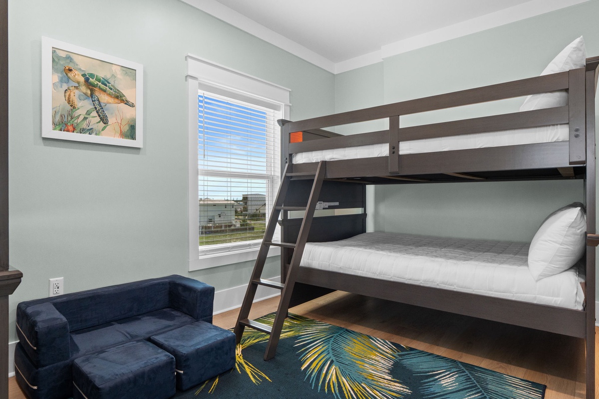 Your kids will love bunking together in this cheerful room with cozy beds, playful sea turtle art, and bright coastal colors perfect for seaside adventures.