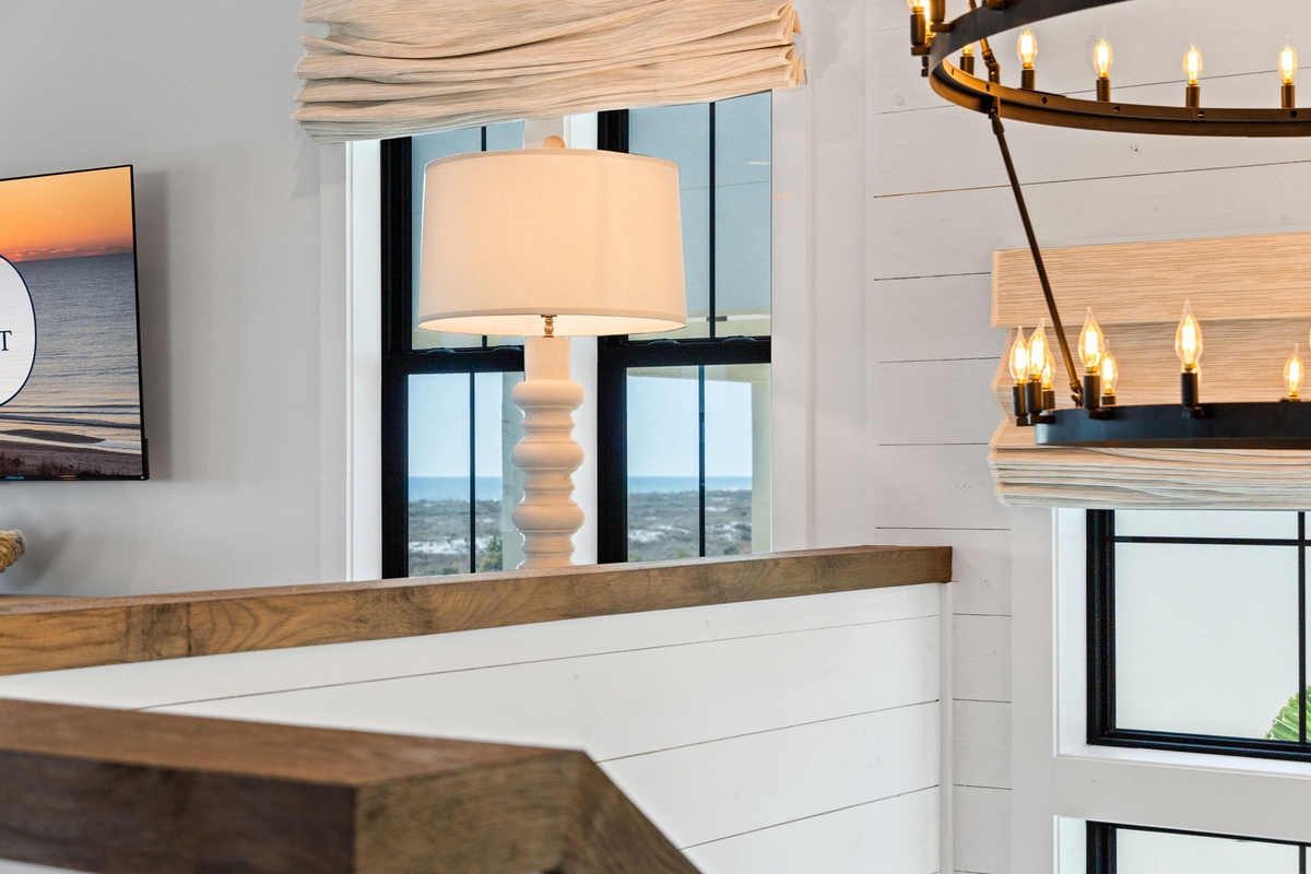 Your bright living space features elegant shiplap walls and warm wood accents, creating a cozy coastal retreat perfect for relaxation.