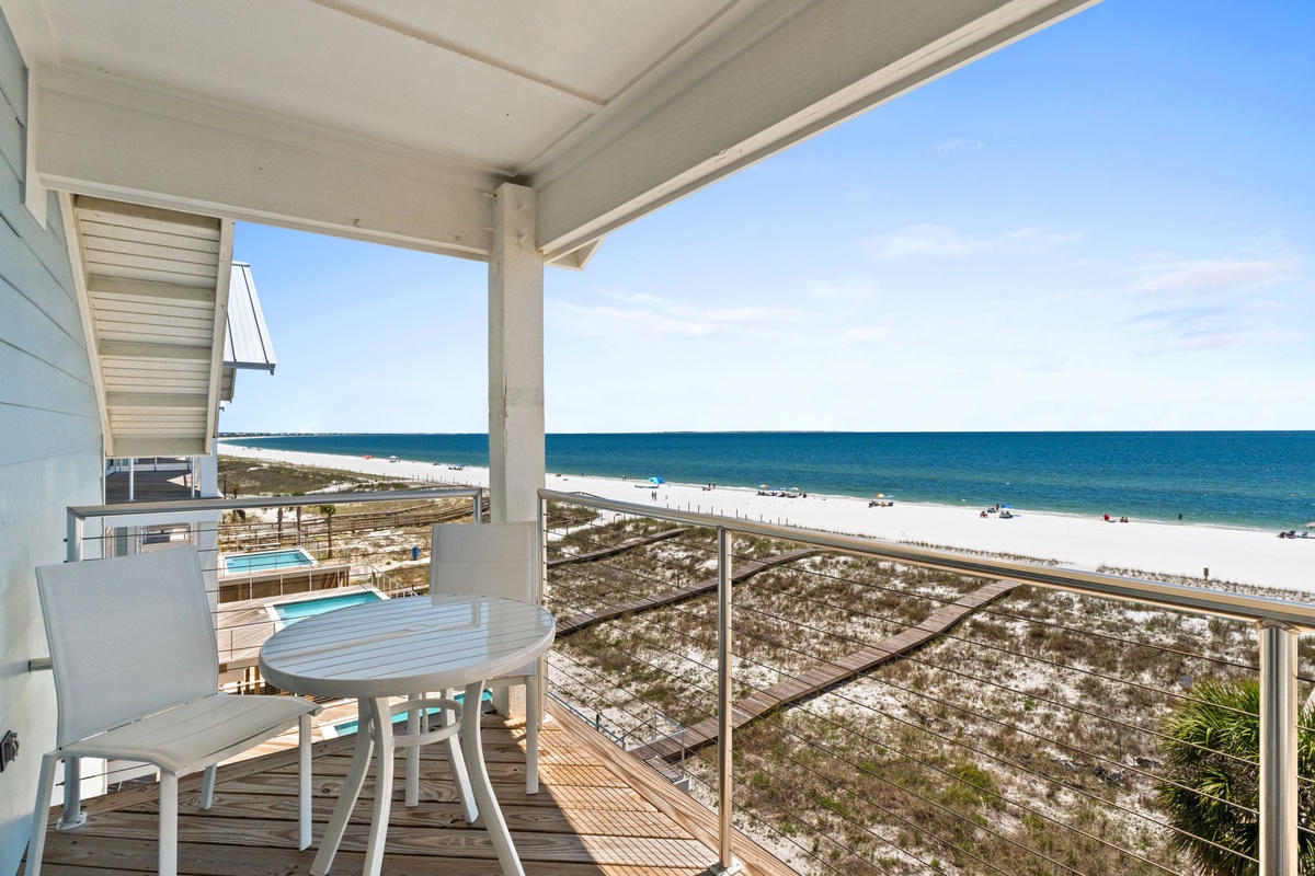 This balcony offers stunning beachfront views, with soft white sand and sparkling turquoise waters stretching to the horizon, perfect for your morning coffee or evening relaxation.