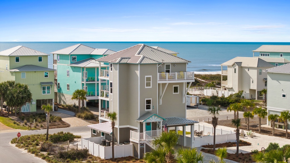 Coastal vacation rental community featuring colorful beachfront homes with ocean access and tropical landscaping.
