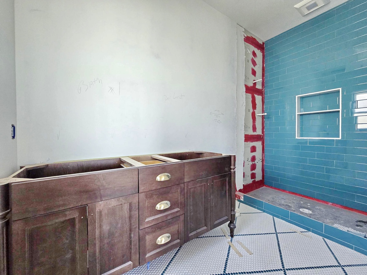 This renovation in progress shows a beautiful blue tile accent wall being restored—your future retreat space taking shape with character and charm.