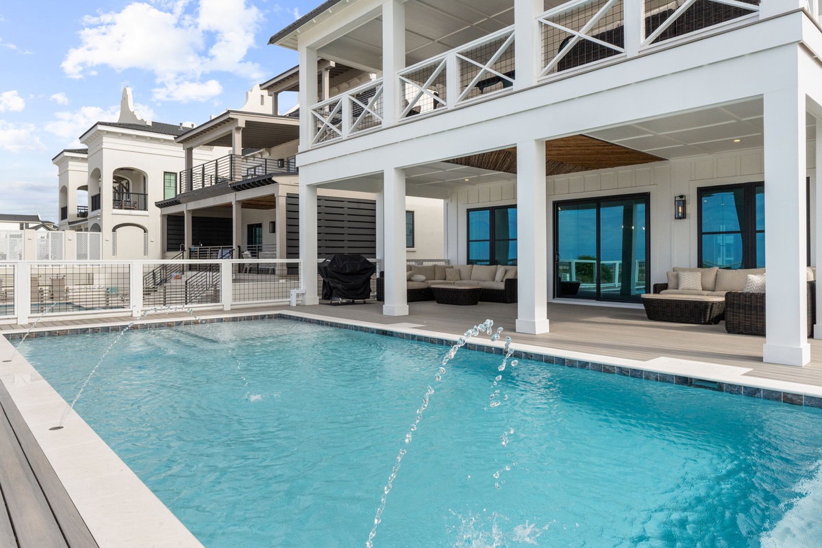 Dive into your private pool oasis with elegant water features, then unwind in the shaded outdoor lounge beneath soaring covered terraces.