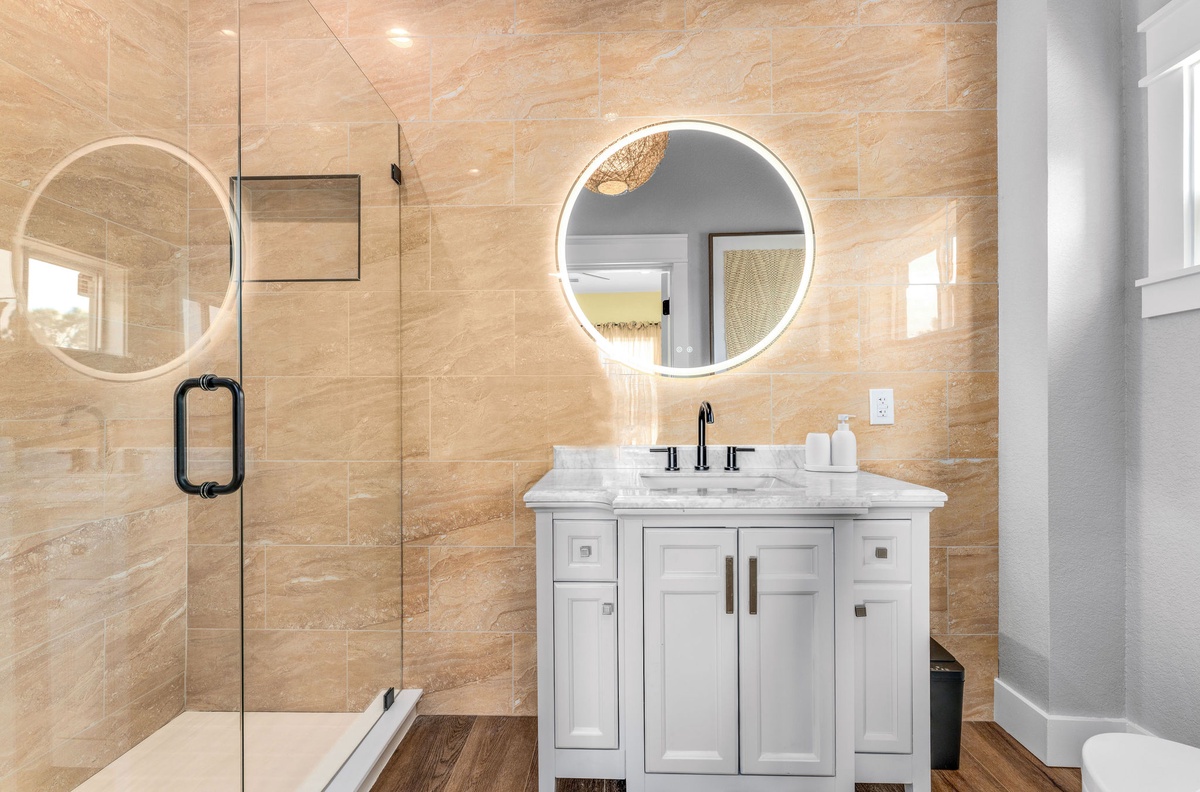 Step into your spa-like bathroom with luxurious marble surfaces, elegant fixtures, and a beautifully lit mirror for your daily routine.