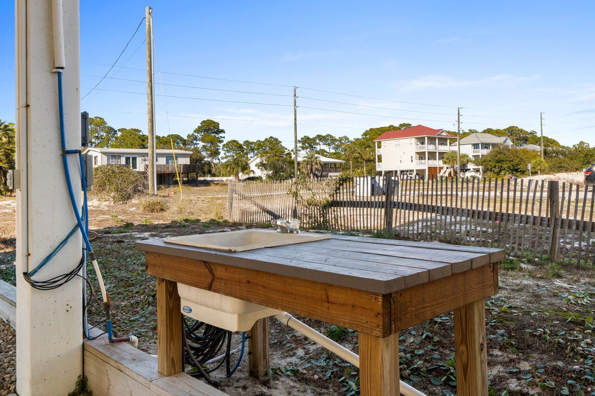 Outdoor fish cleaning station with sink and workspace, perfect for processing your fresh catch in this coastal setting.