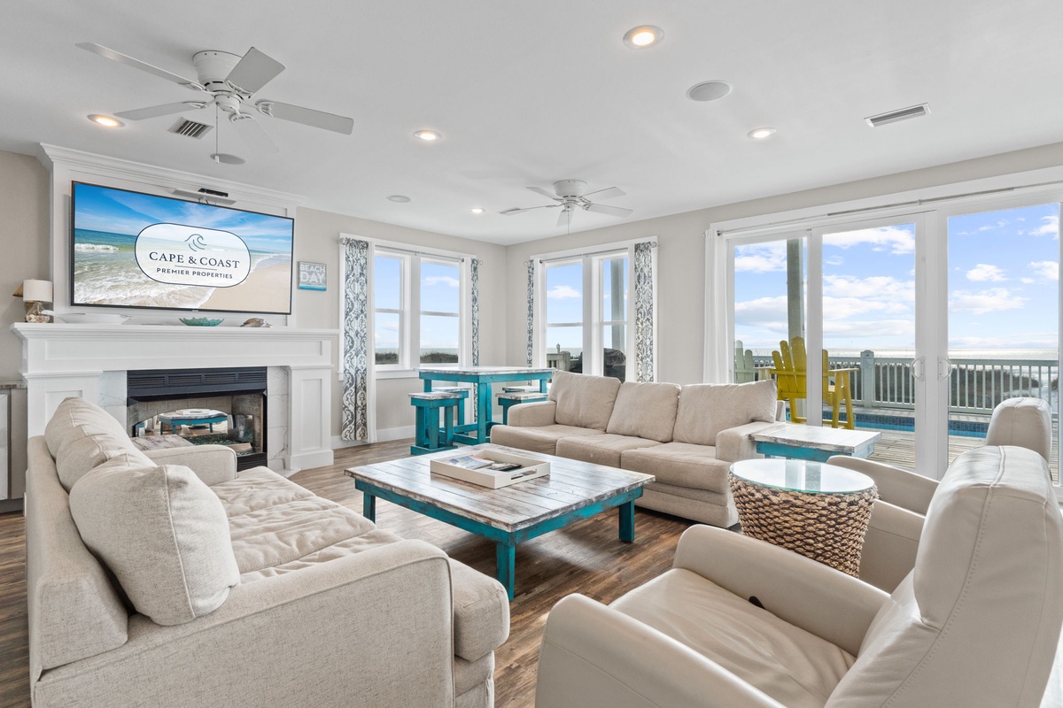 Settle into your spacious living room with plush seating and coastal charm, where large windows frame stunning views for your perfect getaway.
