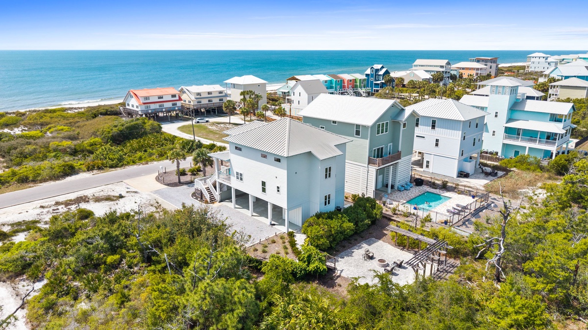 Stunning beachfront property nestled among coastal dunes, just steps from pristine sandy shores and turquoise waters.