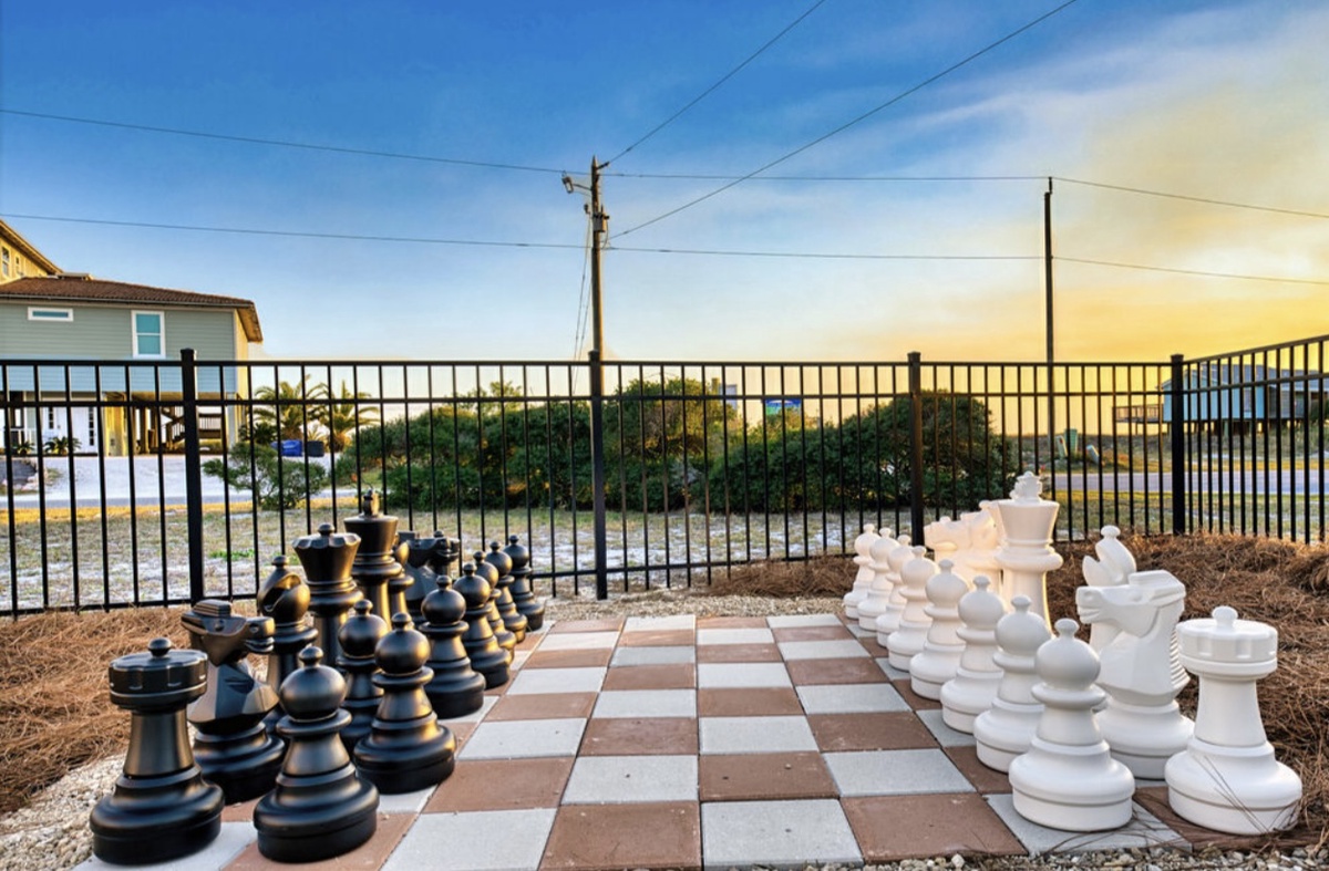 Outdoor giant chess set with neighborhood views, perfect for strategic games under the open sky.