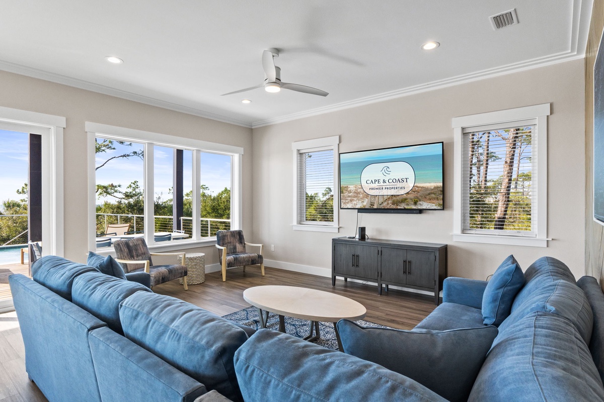 Sink into plush blue sofas while enjoying natural light streaming through large windows in this elegant living space.