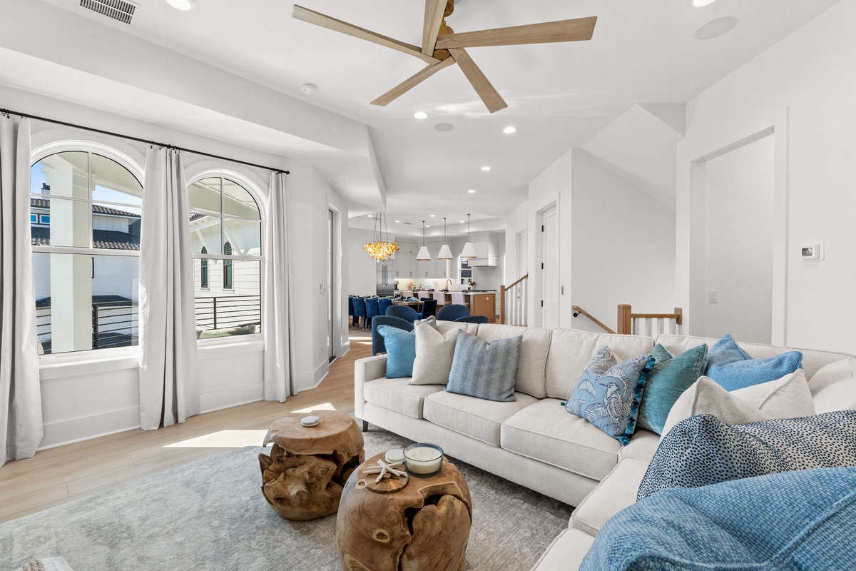 Sink into plush sofas adorned with ocean-blue pillows in your bright, airy living space with soaring ceilings and French doors opening wide.