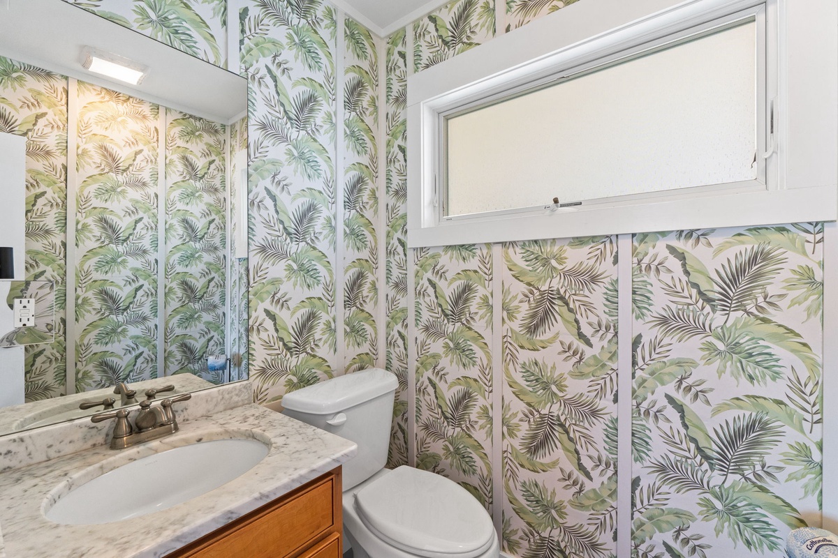 Freshen up in your private bathroom, where tropical palm-print walls and natural light create a relaxing, vacation-ready atmosphere. The marble vanity adds a touch of elegance.