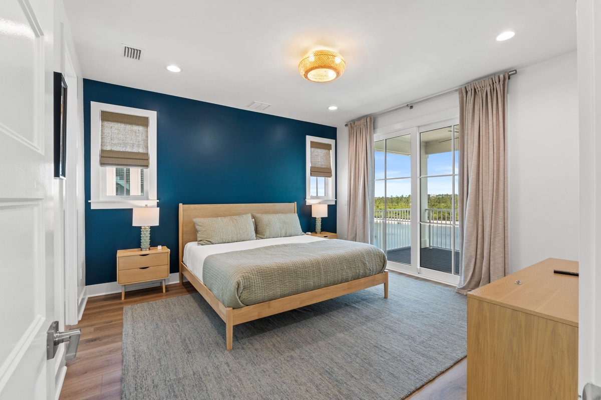 Sink into the plush bed and wake to serene balcony views. A bold teal accent wall and golden lighting create your own peaceful retreat to recharge.