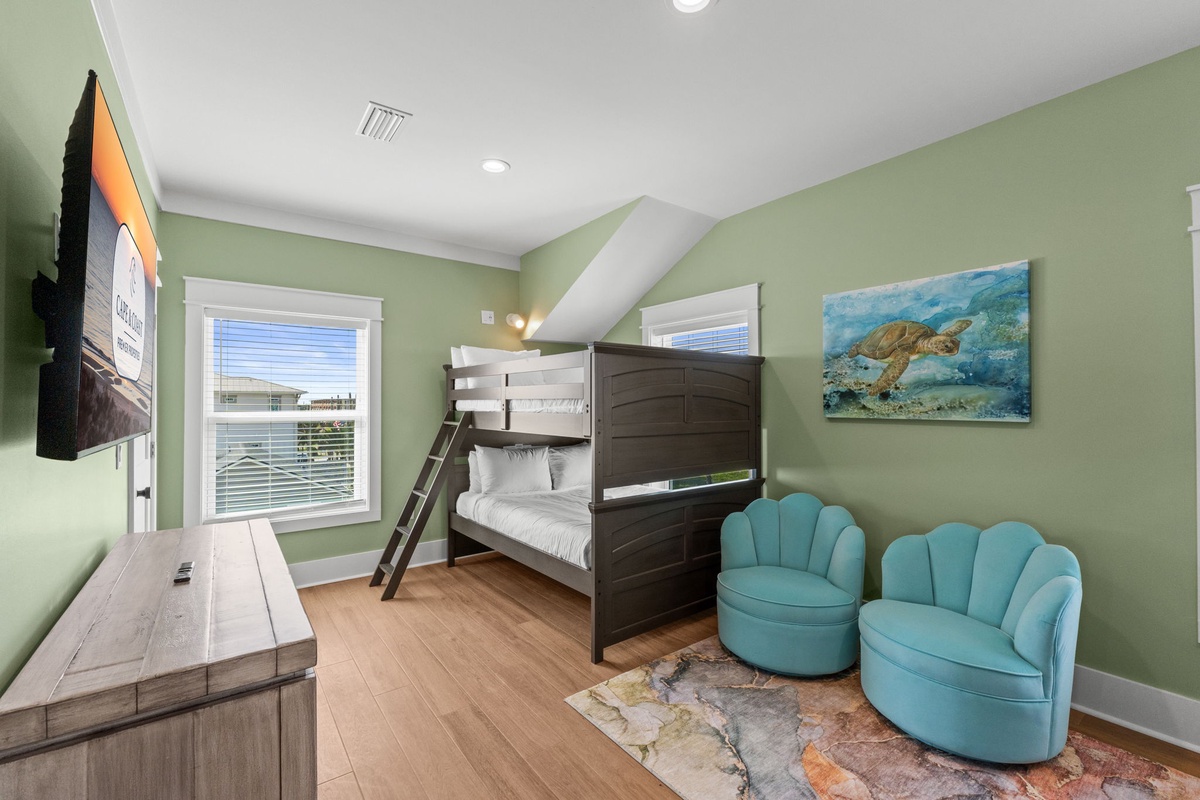 Settle into this cozy coastal bedroom, where soft green walls and cheerful ocean artwork set a relaxing tone for your family's stay.