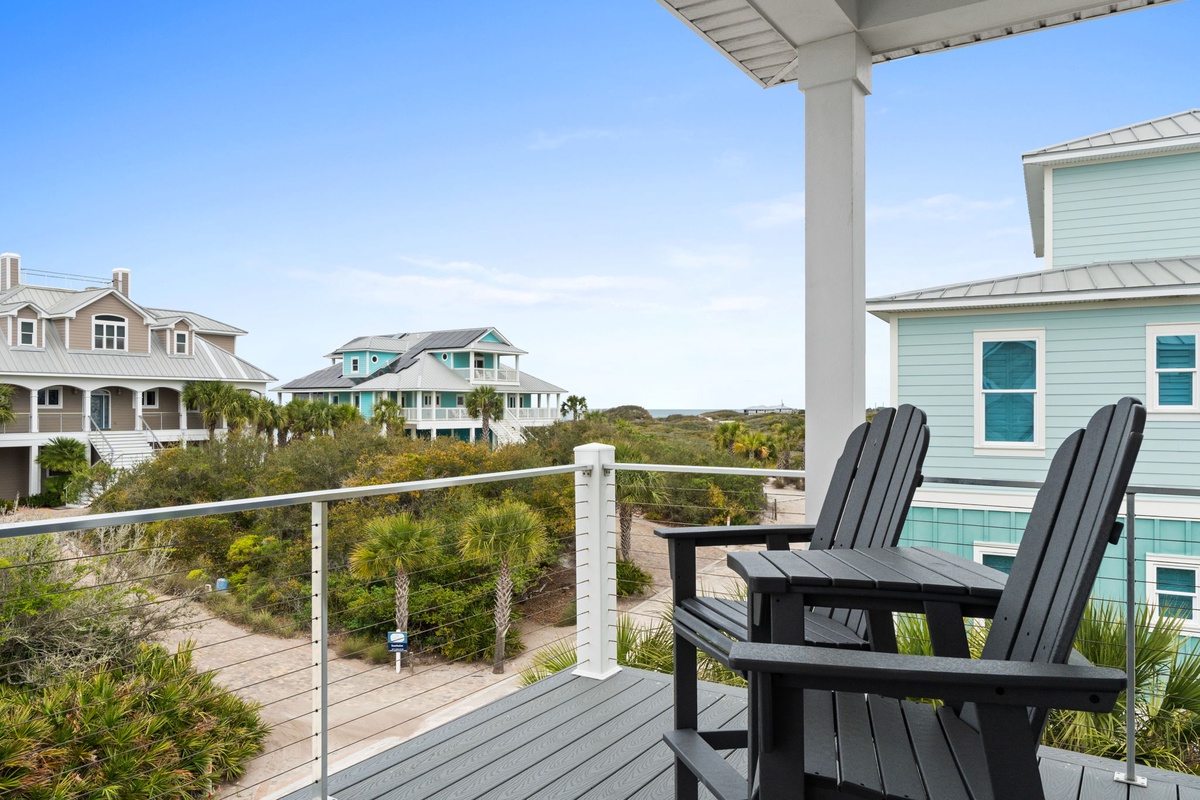 Relax in comfortable Adirondack chairs on your private balcony, soaking in panoramic views of colorful beach homes and lush coastal landscapes.