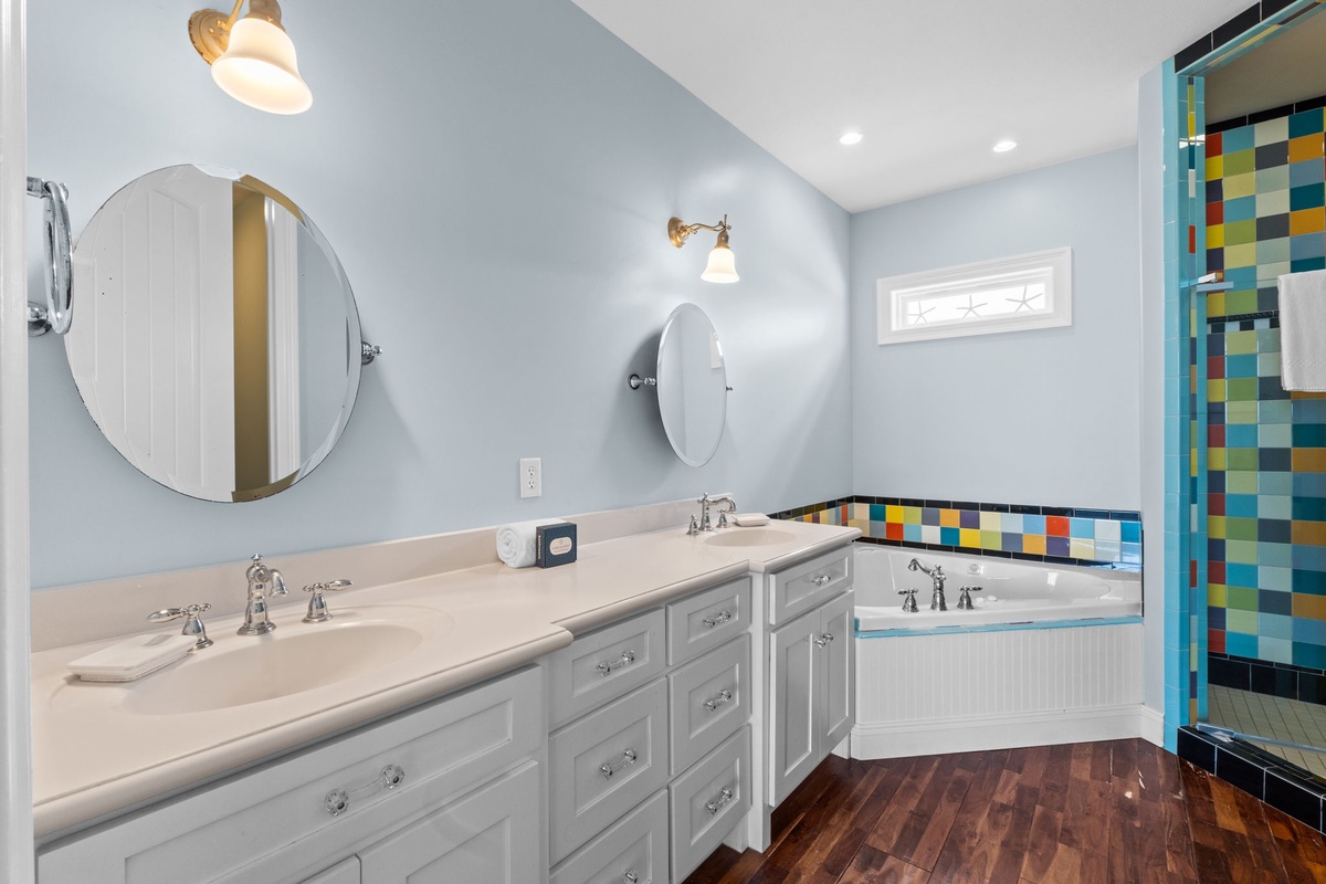 Refresh and unwind in your bright, modern bathroom with dual vanities and a colorful tiled tub — everything you need to feel right at home.