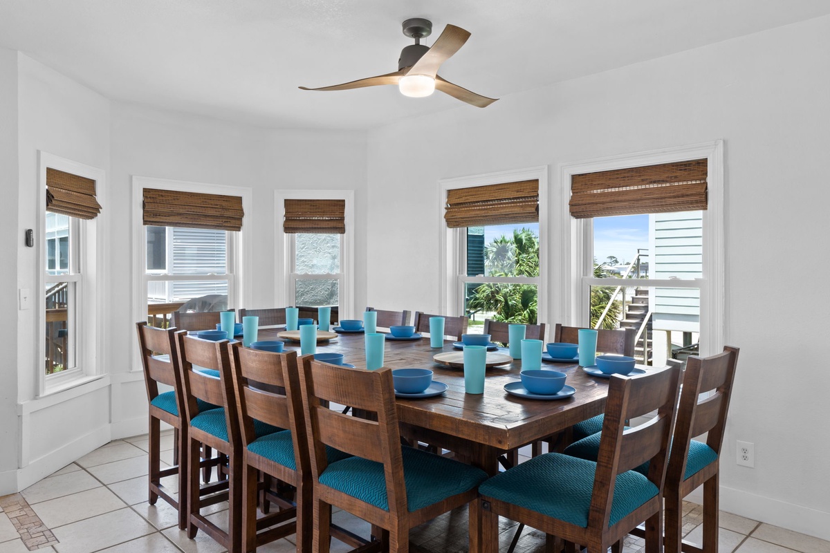 Picture yourself gathered around this spacious dining table with friends and family, enjoying shared meals and ocean breezes through abundant natural light from five generous windows.