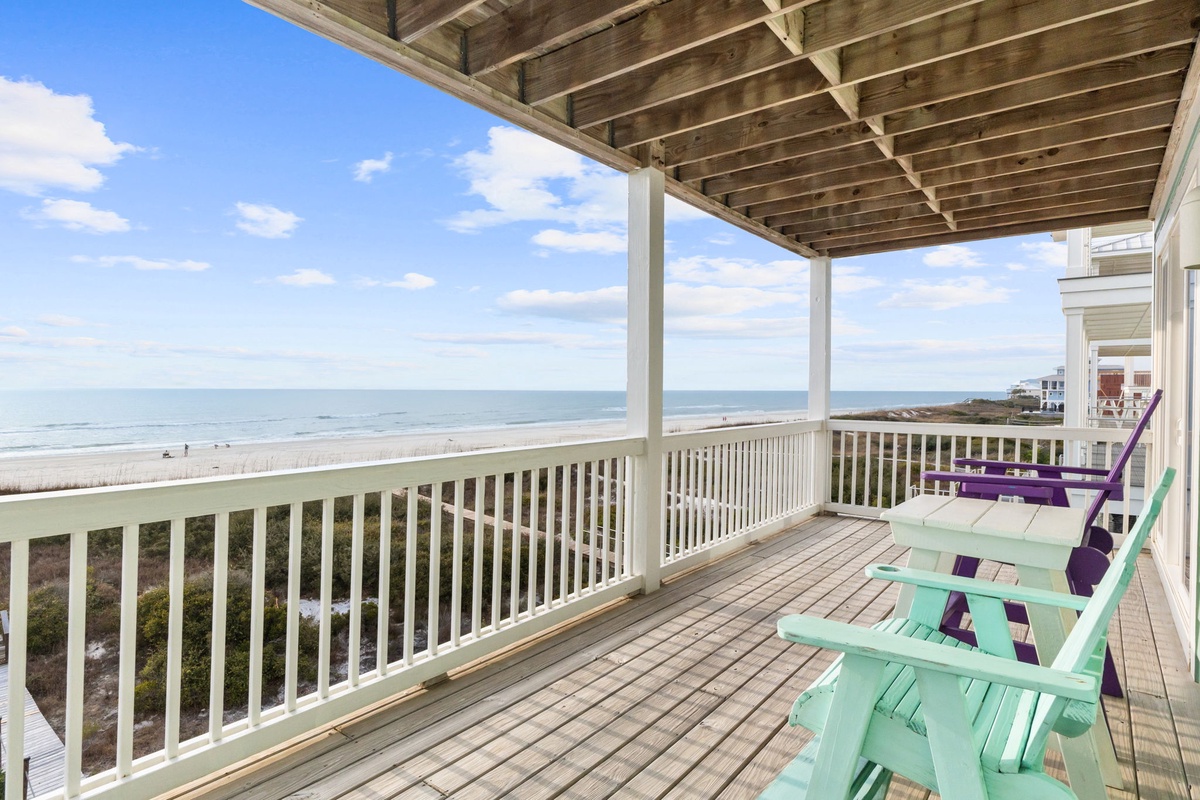 Relax in colorful Adirondack chairs on your private covered deck with stunning ocean views and beach access.
