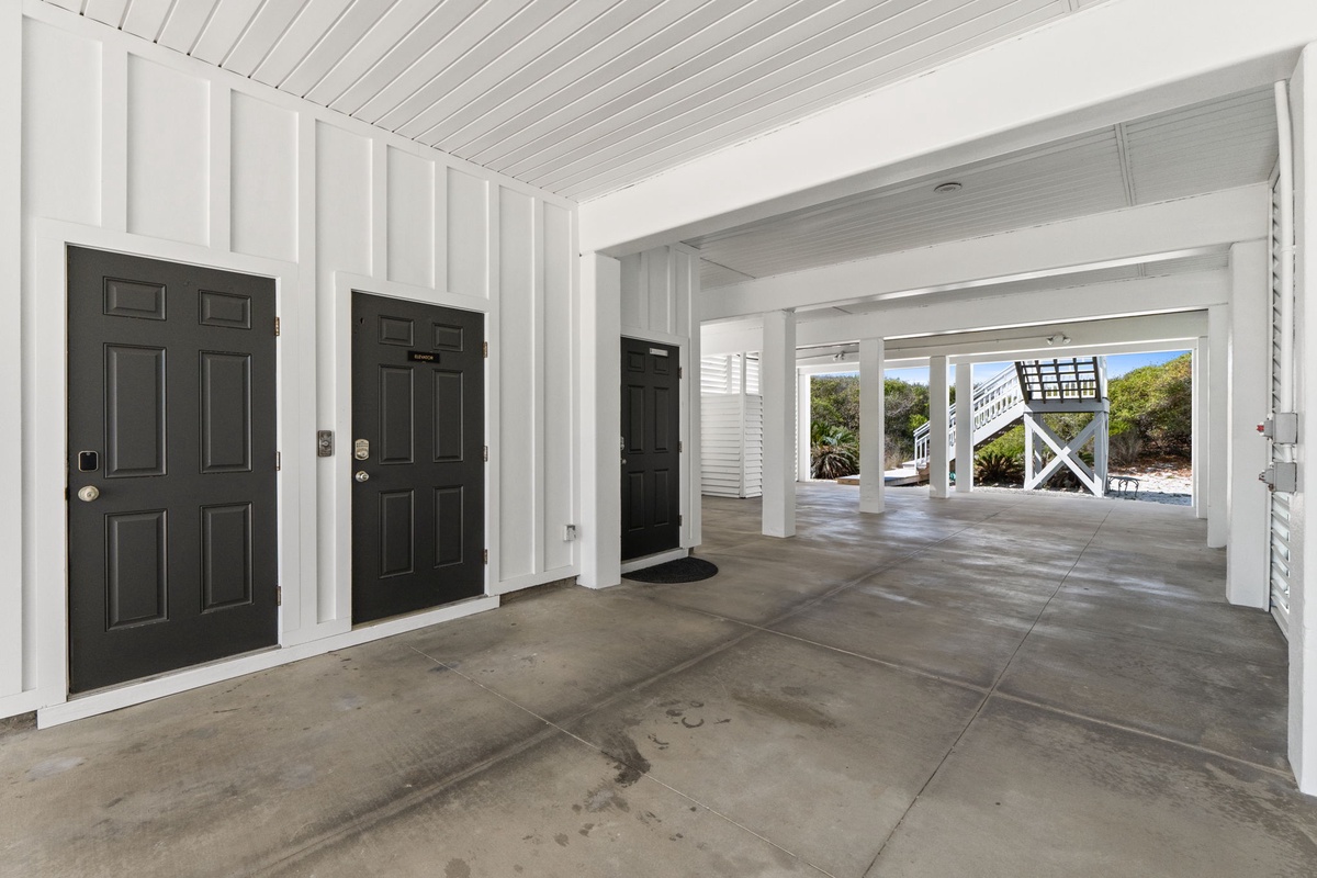 Spacious covered parking garage with multiple entry points and elevated design typical of coastal properties.